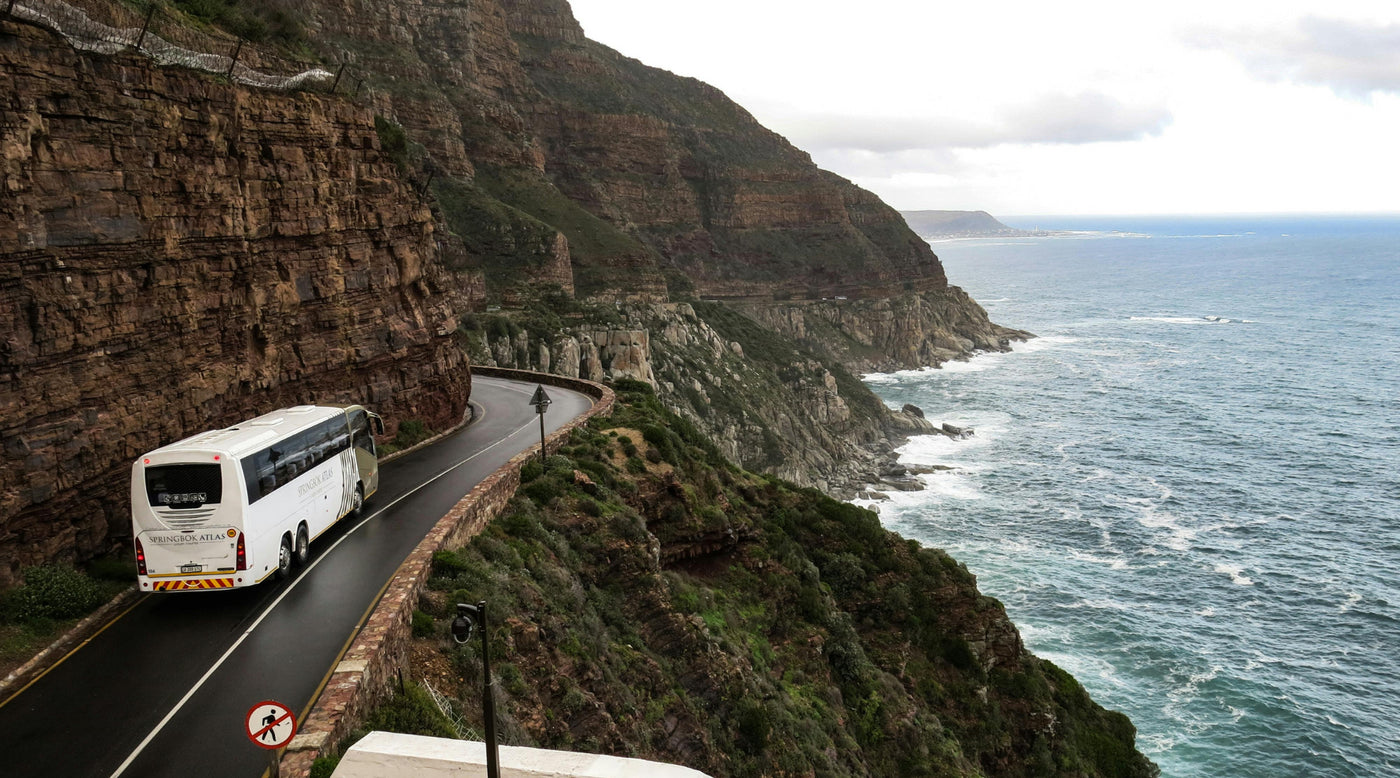 Ein Bus fährt auf einer Straße an der Klippe entlang